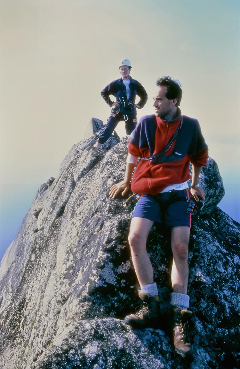 To menn på ein kvass fjelltopp, i klede frå 80-talet.